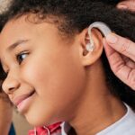 Hearing aid fitted on a smiling child 2026 03 24 03 23 31 utc 1440x700